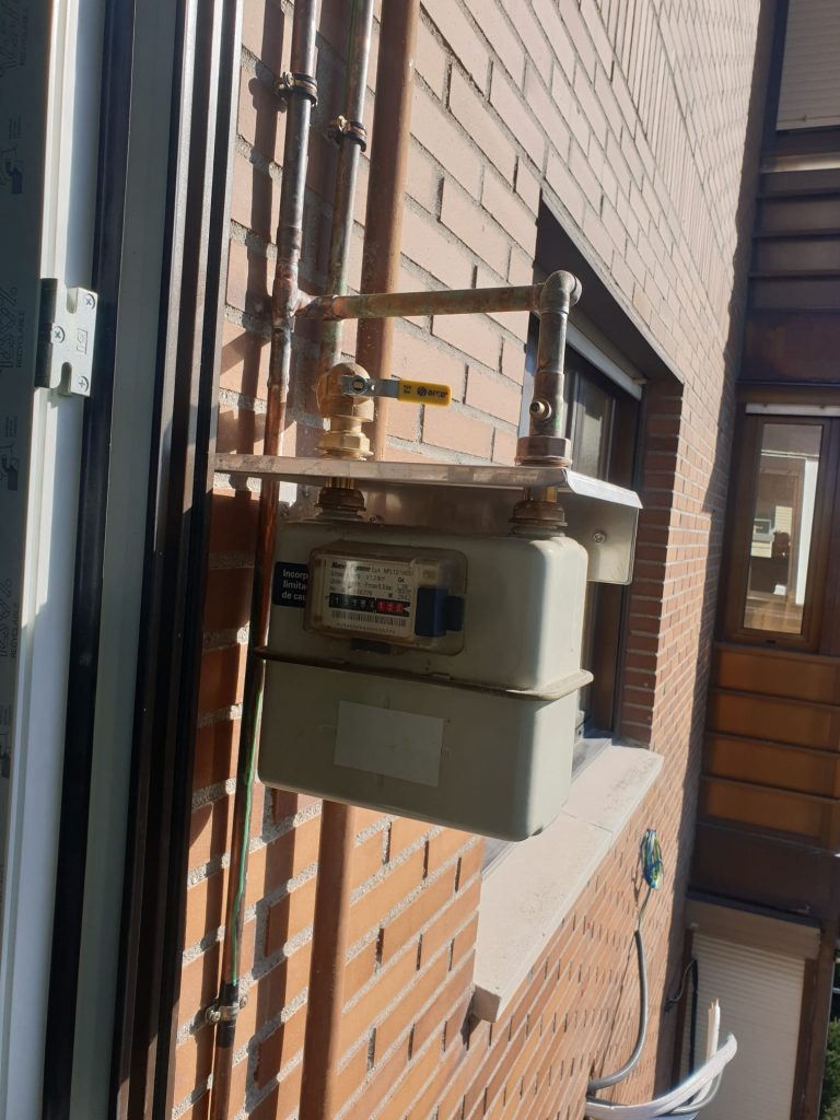 Contador de gas e instalación exterior en una fachada.